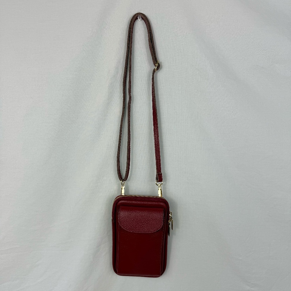 Deep red leather crossbody Uno Alla Volta mini bag with zipper and pockets.